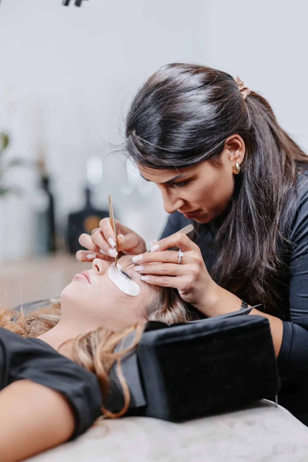 Merve Durmus arbeitet an der Wimpernverlängerung einer Kundin auf der Behandlungsliege